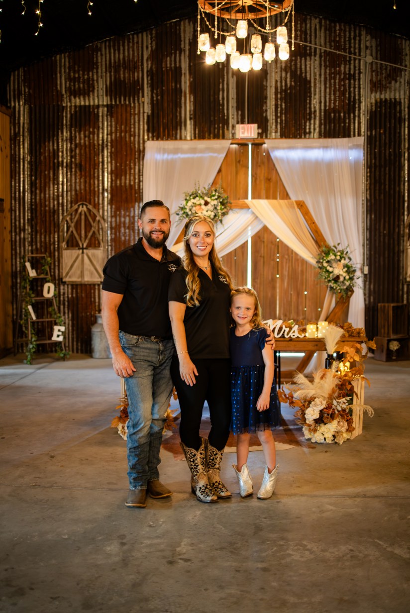 Tiffany and Jonathon with their daughter inside the decorated barn