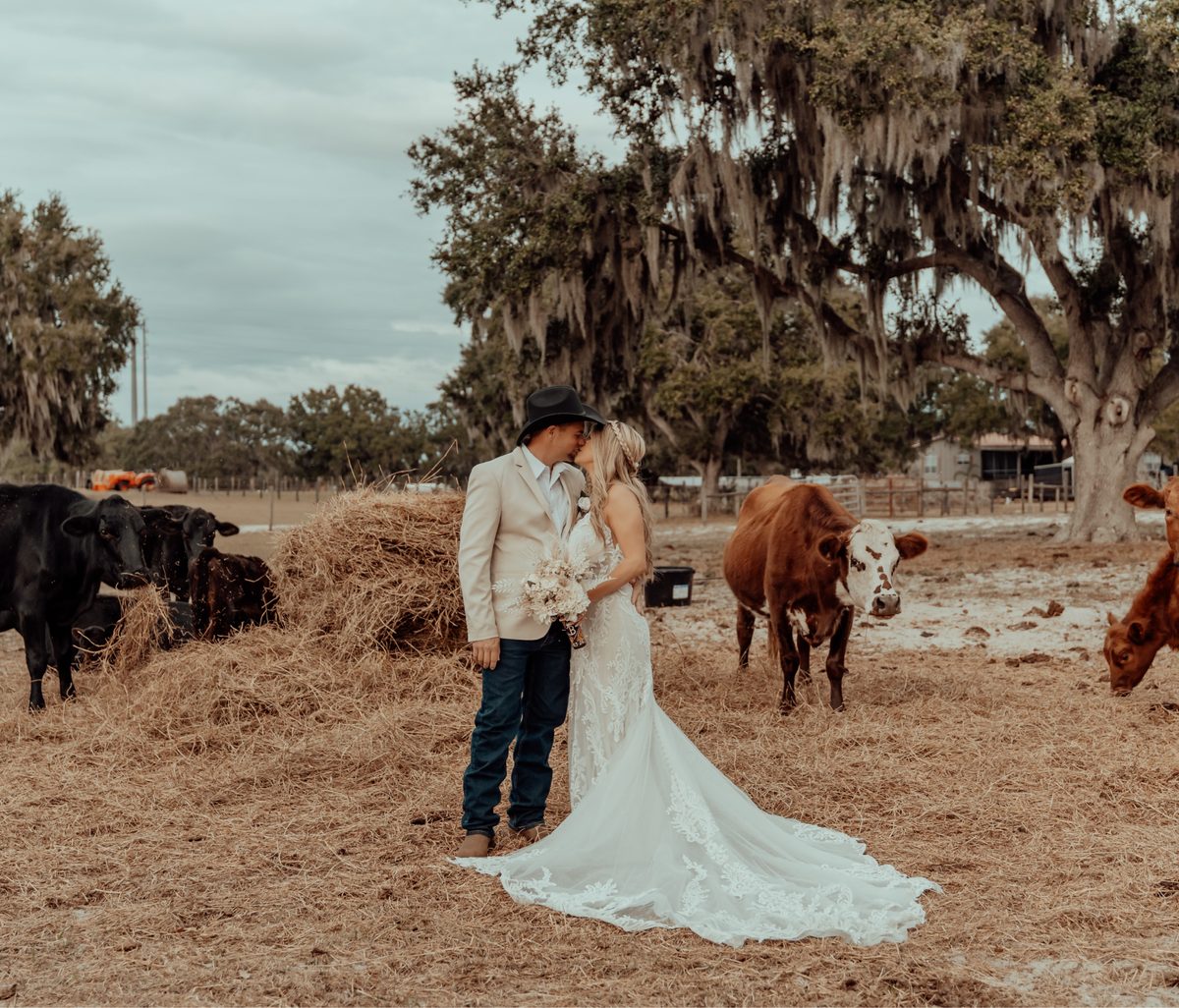 A groom twirling his bride on the lawn under the live oaks
