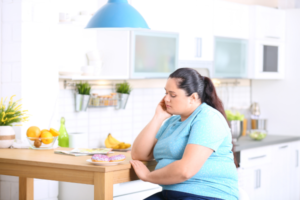 A woma sitting thinking about her weight