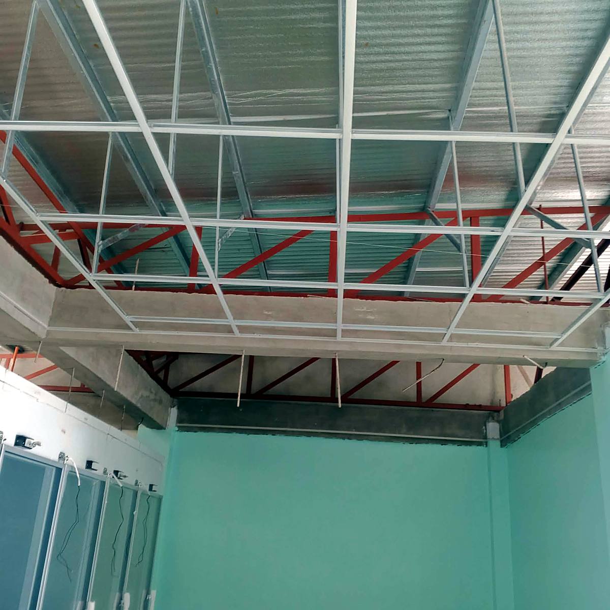Ceiling framing installation under steel trusses — Triple J Builders