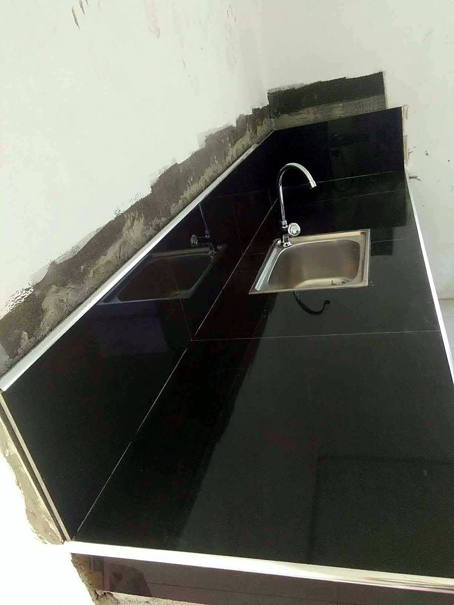 Black tiled kitchen counter with stainless steel sinks — Triple J Builders