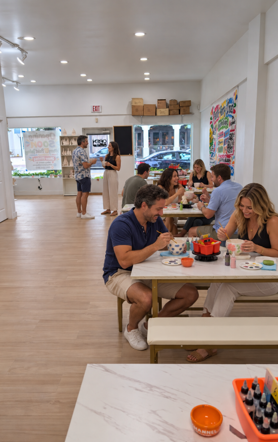 Guests painting pottery and mingling at Pottery U Paint Delray