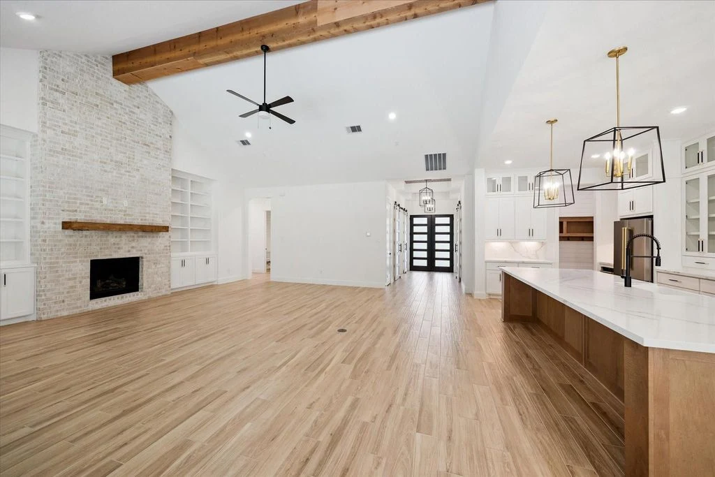 Completed living space with vaulted ceiling, fireplace, and open kitchen