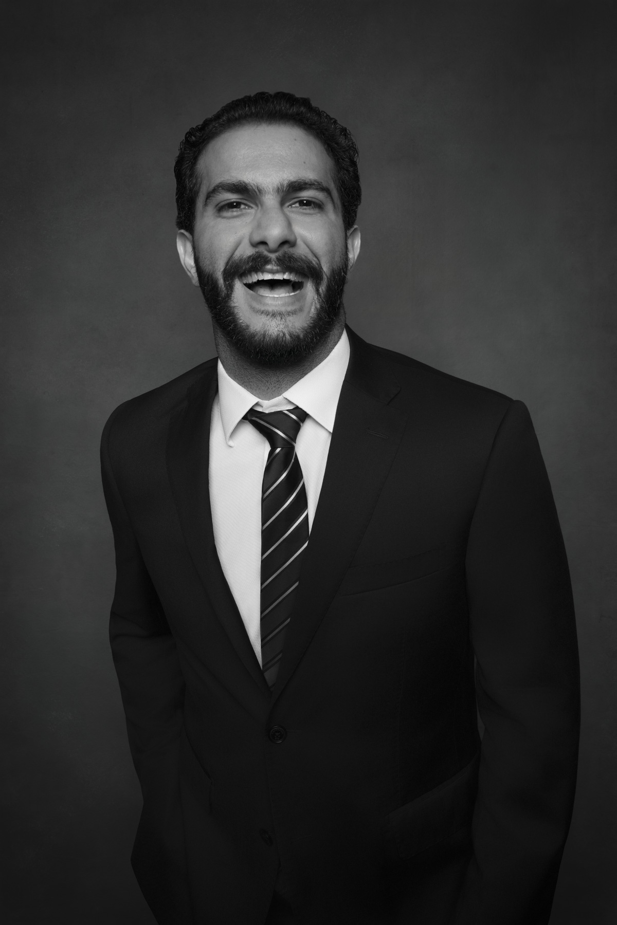 Elegant black and white wedding guest portrait of a man in a suit photographed in a professional studio at a luxury wedding reception. Elegant black and white wedding guest portrait of a man in a suit photographed in a professional studio at a luxury wedding reception.