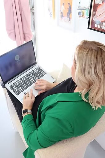 Lou sitting in chair with laptop