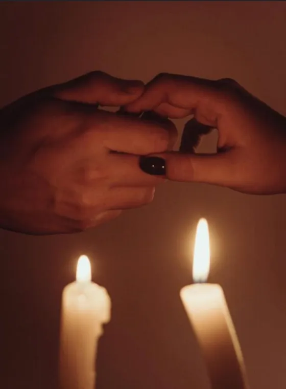 Cartas de tarot, vela encendida y cristal sobre fondo oscuro