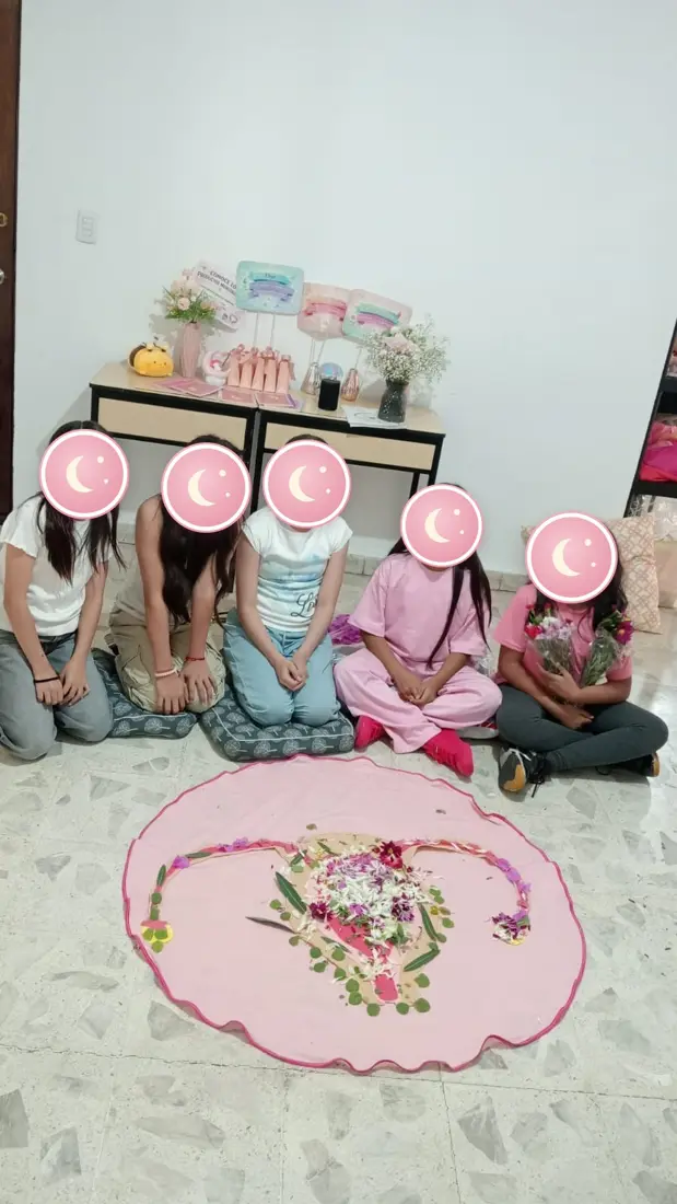 Grupo de niñas sentadas junto a su mandala de flores terminado.