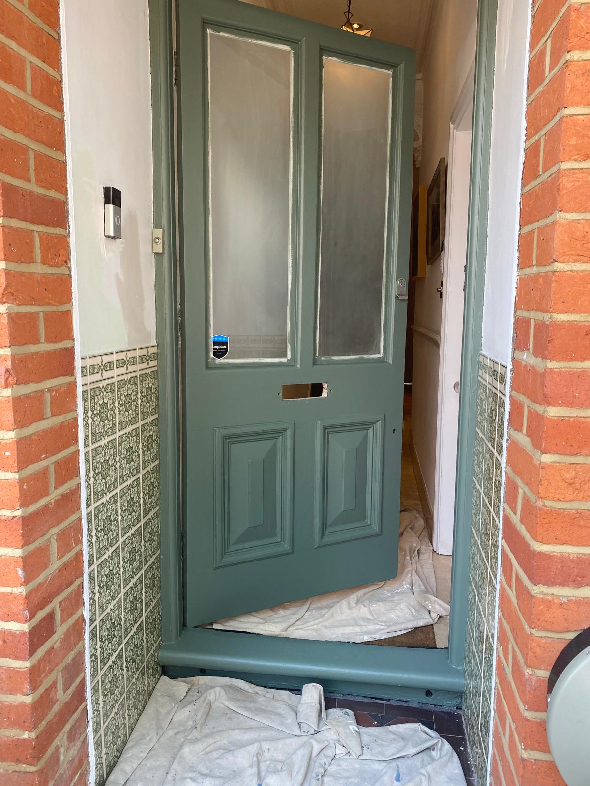 Victorian front door mid-restoration showing fresh paintwork in progress in Epsom