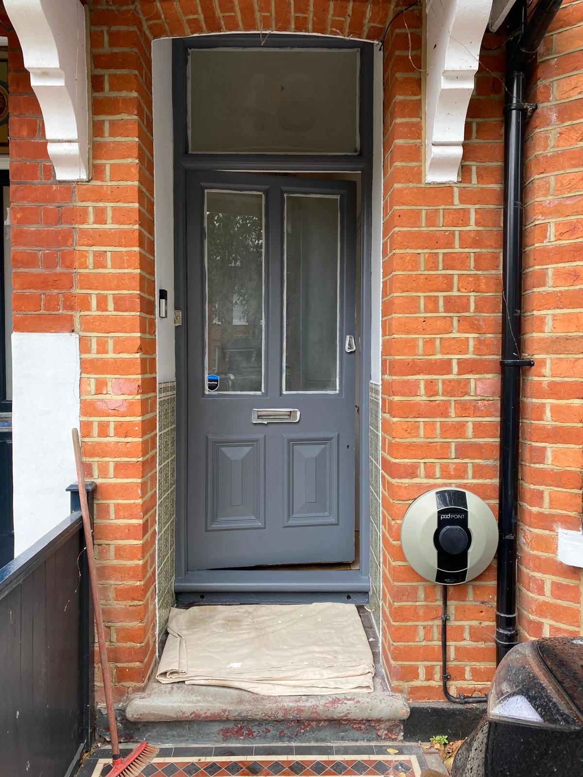 Front door stripped back to bare timber during surface preparation in Epsom
