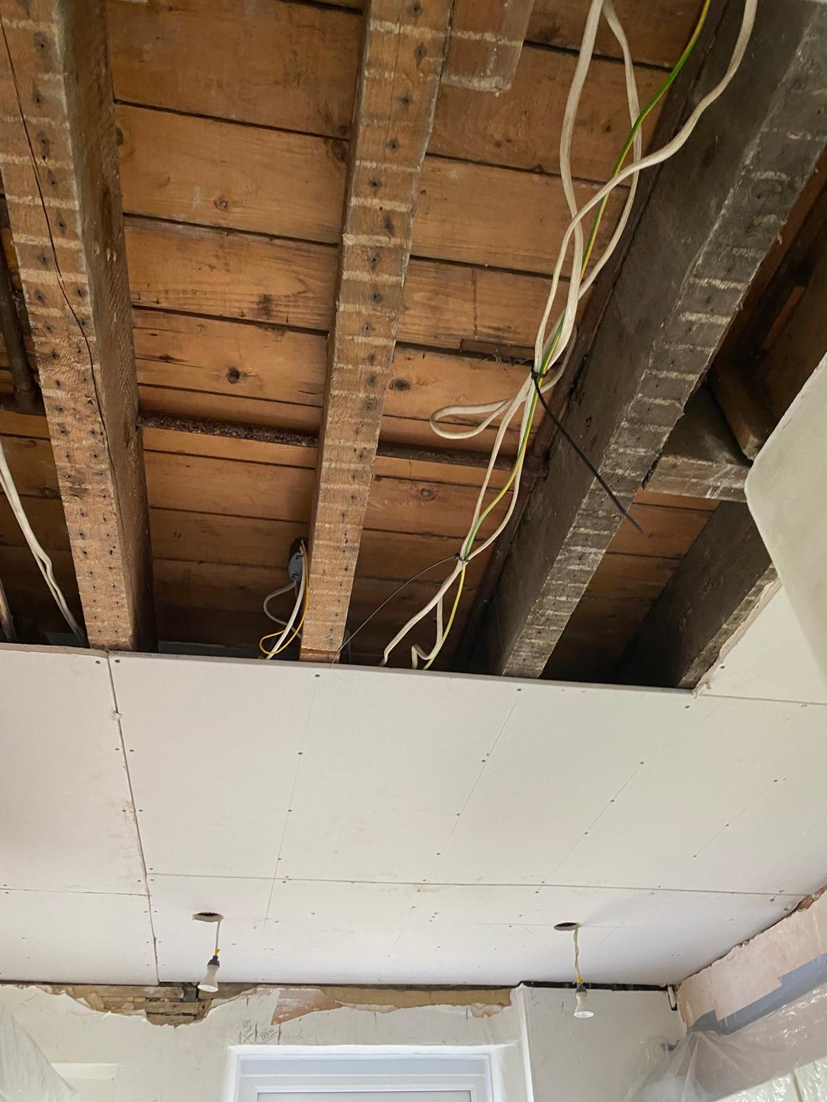 Kitchen ceiling stripped back to joists during full ceiling replacement job in Epsom