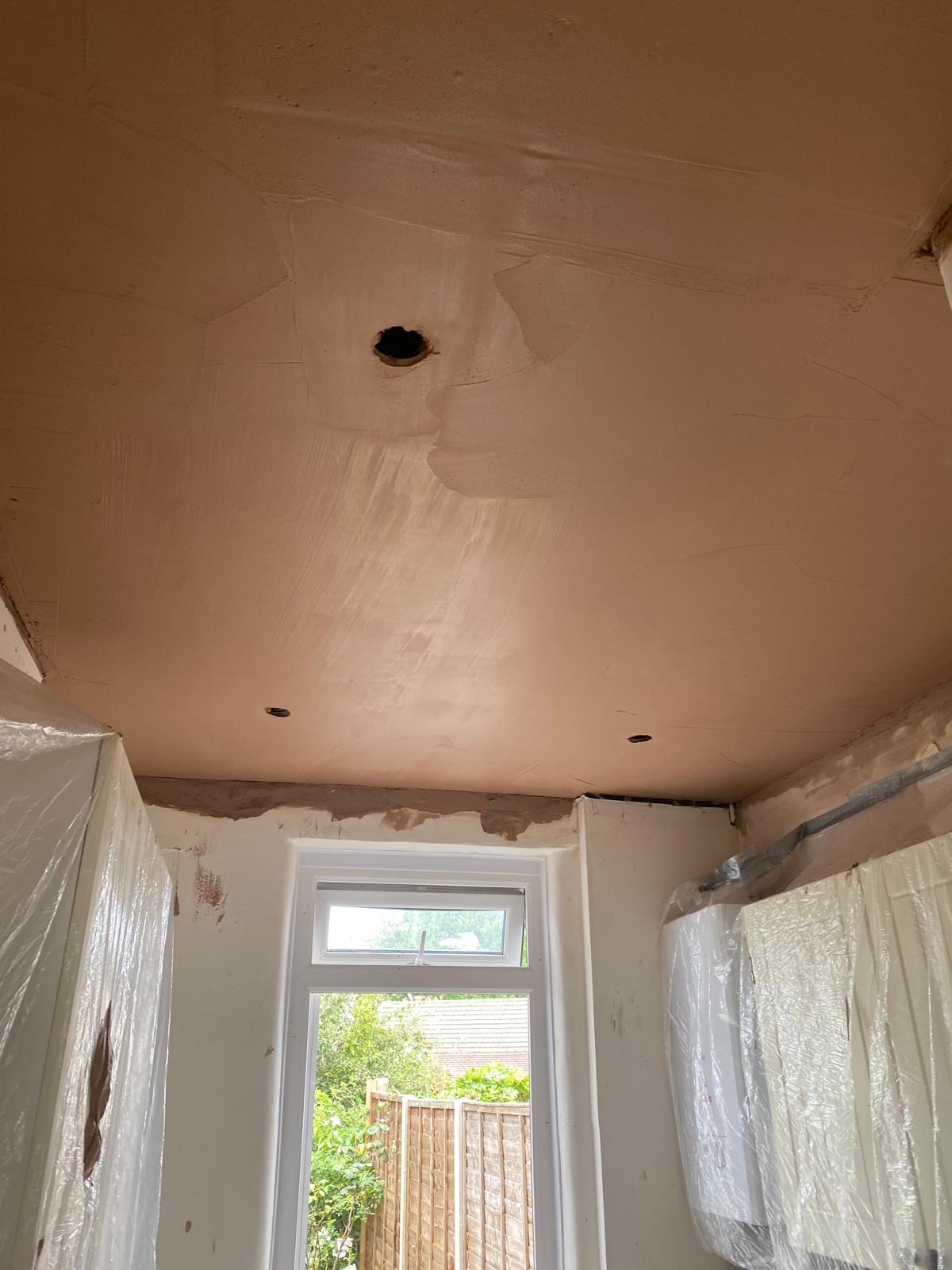 First coat of skim plaster being applied to new kitchen ceiling in Epsom
