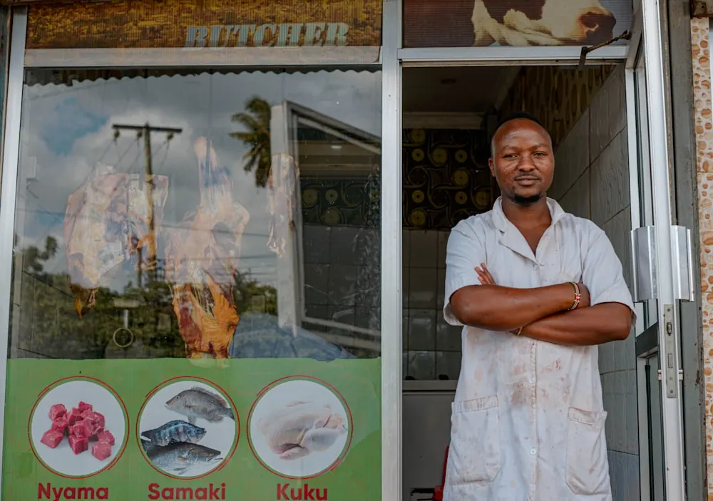 A business owner standing in the doorway of his shop