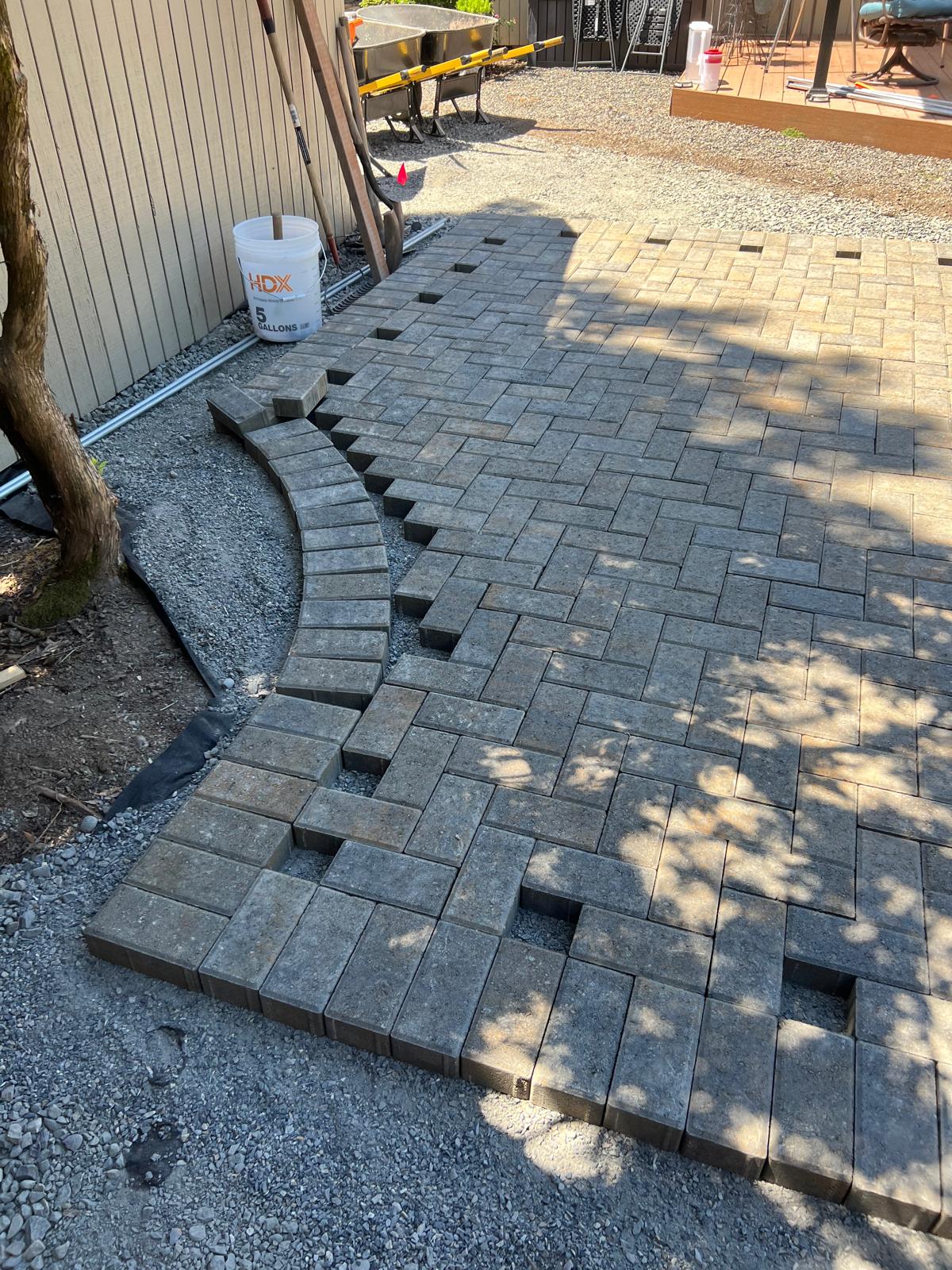 Curved paver patio install completed by Metro Mowing Services and Maintenance LLC
