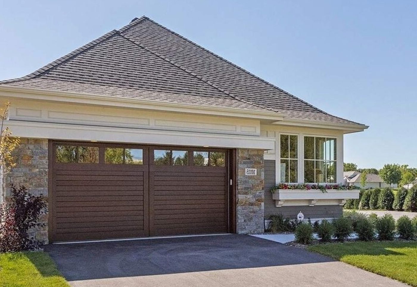 Exterior of The Orchard Villa with stone and wood garage