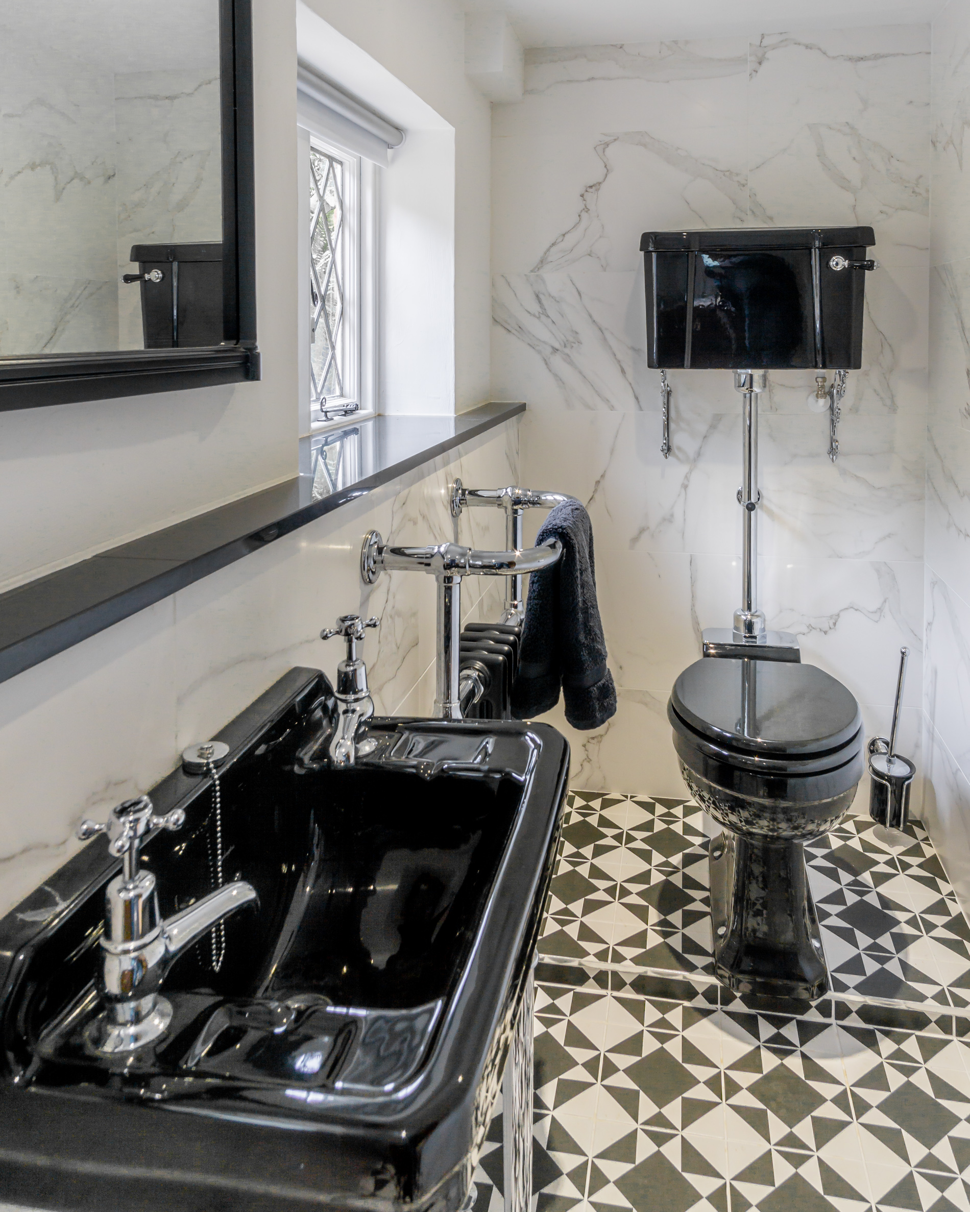 Traditional black cloakroom with patterned floor and period sanitaryware
