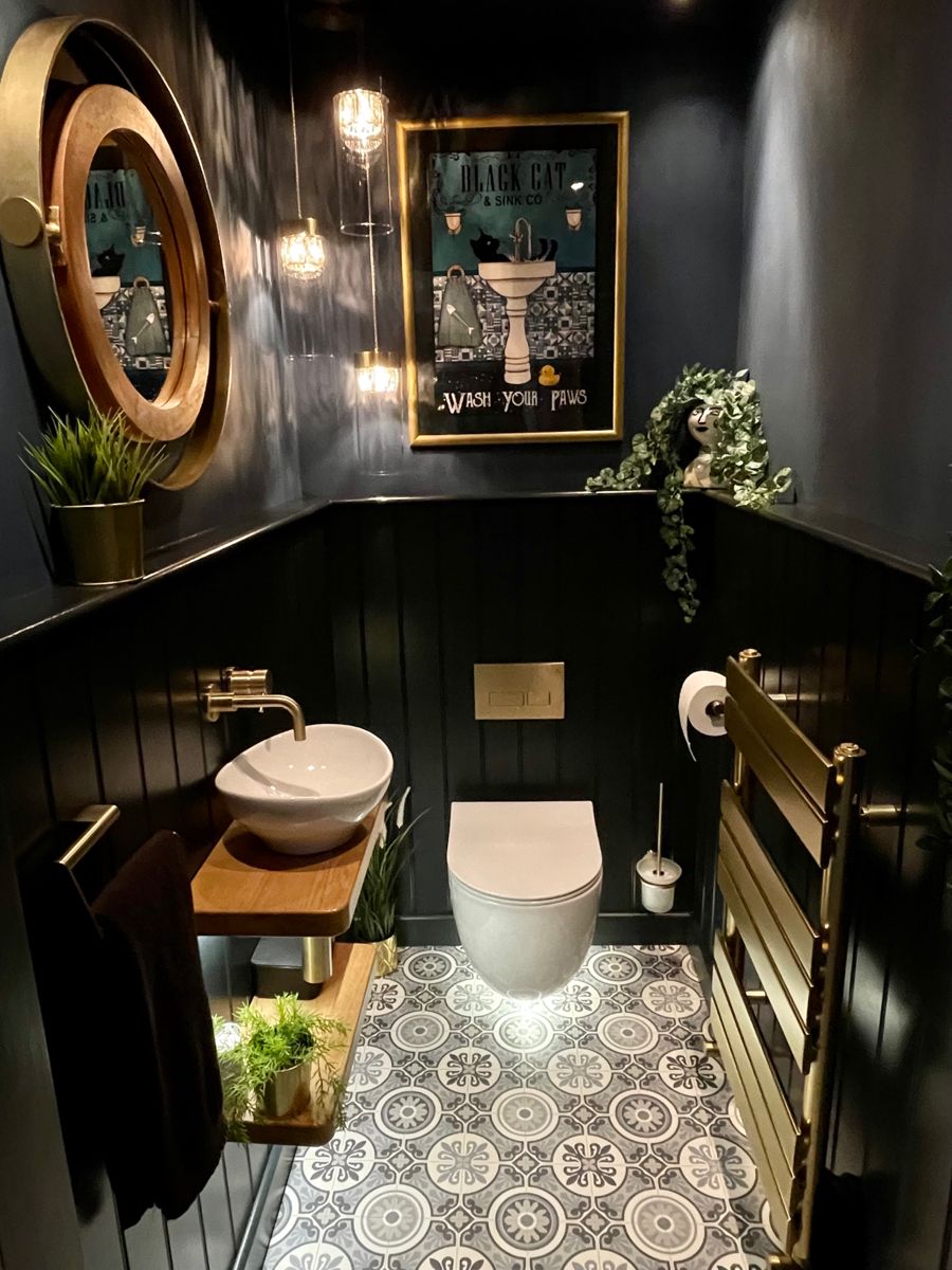 Dark luxury cloakroom with brass fittings, panelling and patterned floor
