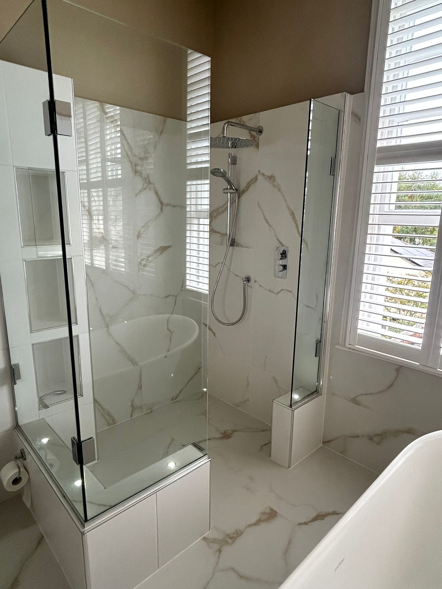 Luxury wet room with continuous tiled surfaces