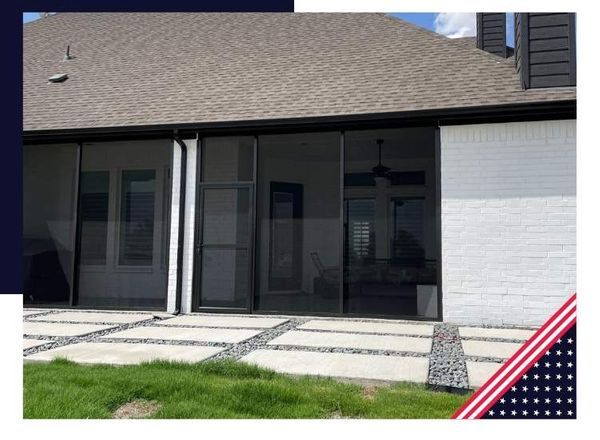 Screened-in porch with concrete patio under a roof beside a lawn