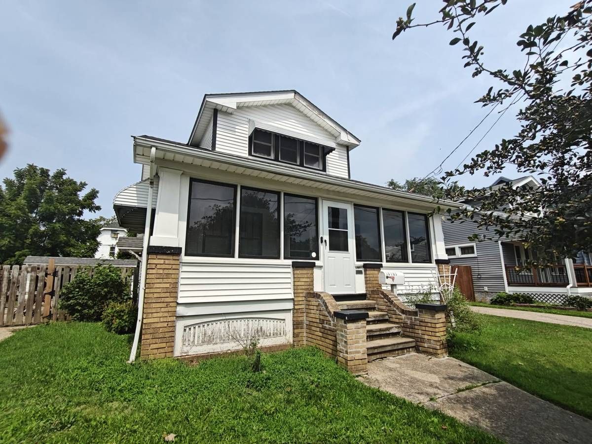 Front of 18703 Kewanee Avenue, a white 1.5 story Cape Cod with an enclosed porch