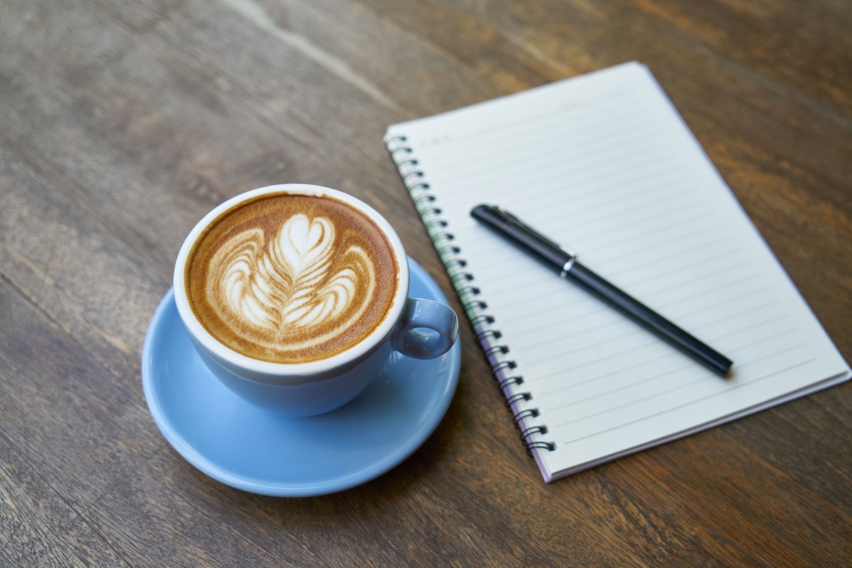 Un café et un carnet ouvert sur une table