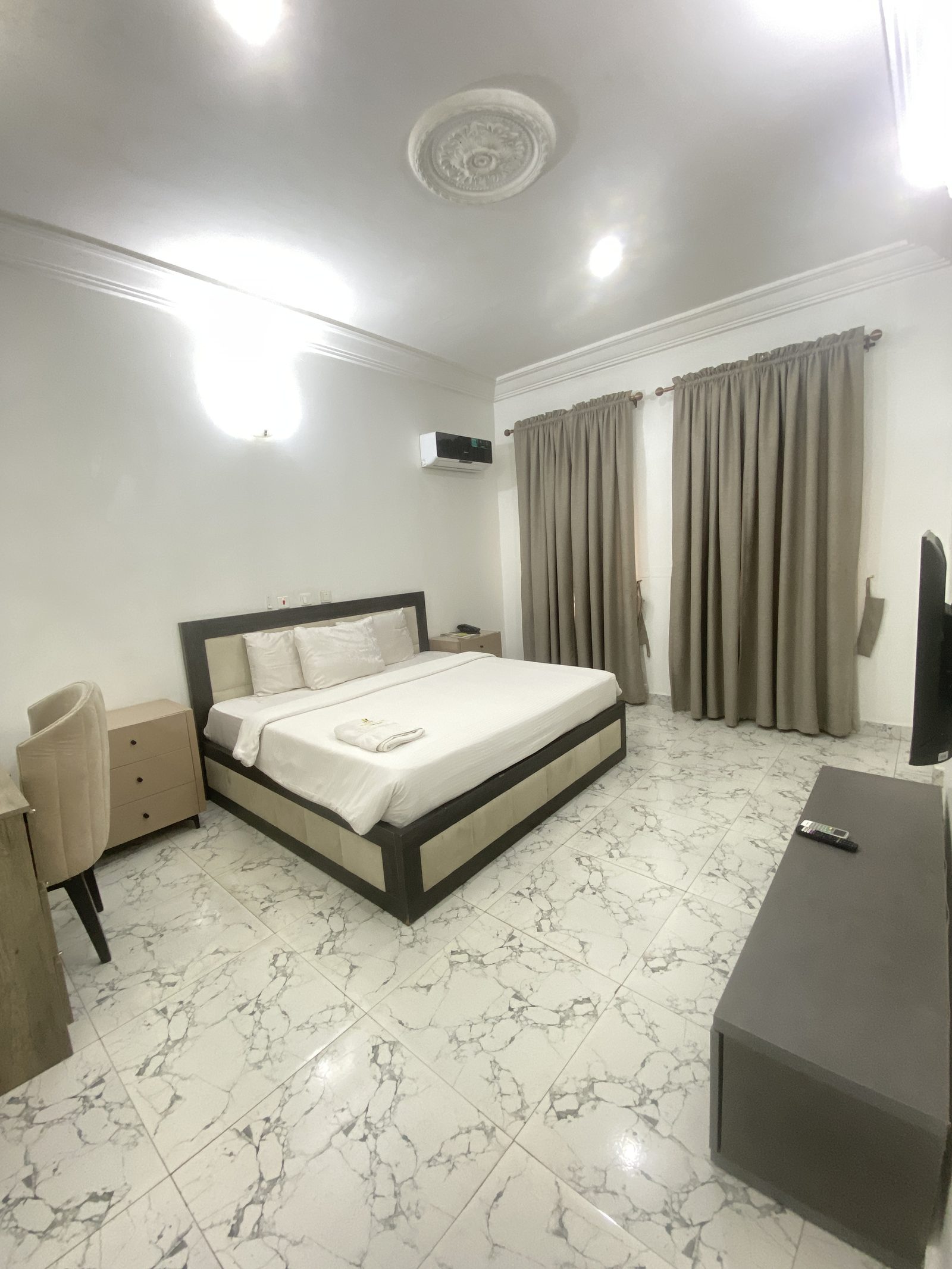Executive Suite living room with facing armchairs, glass coffee table and wall-mounted television