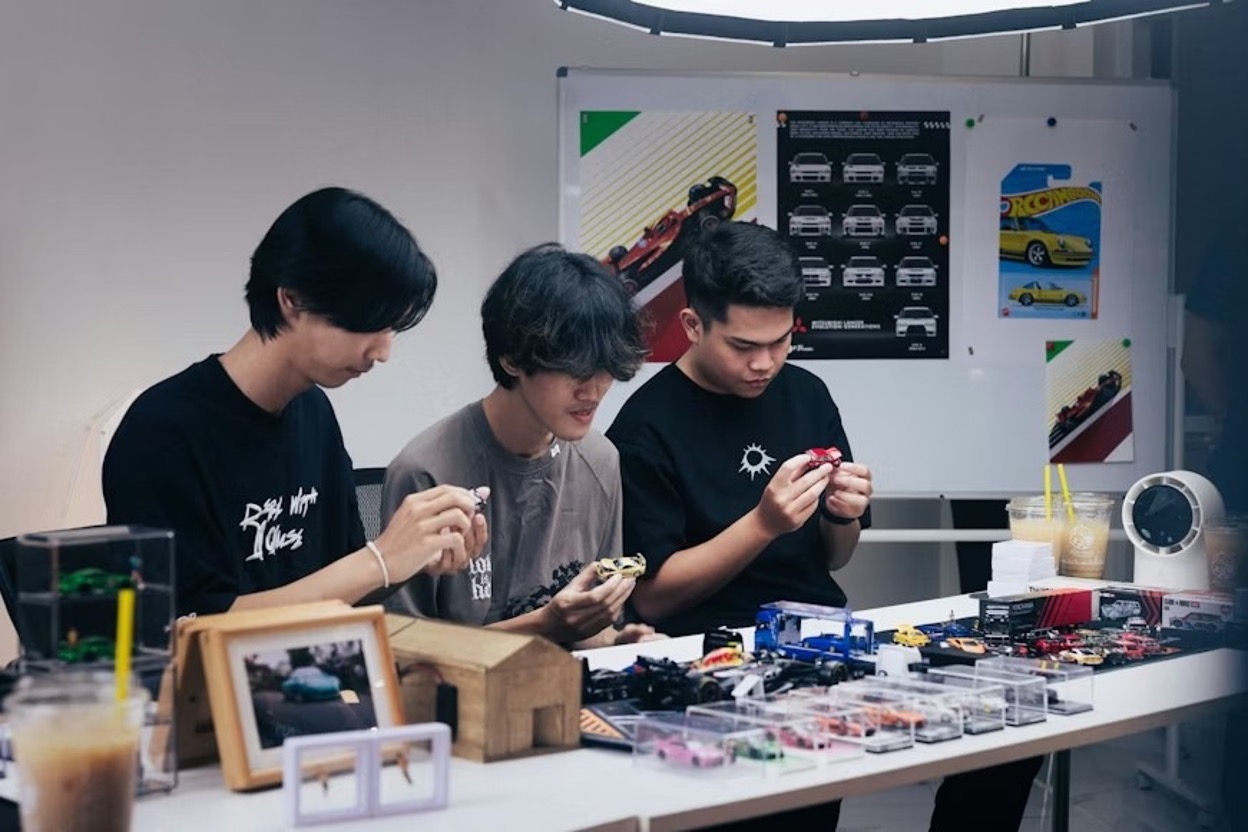 A team of young tech professionals working on miniature car prototypes A team of young tech professionals working on miniature car prototypes
