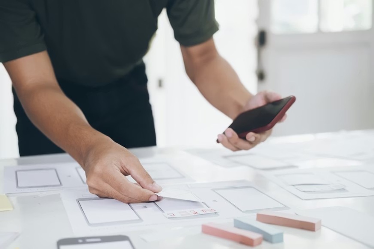 A person holding a smartphone carrying out a usability test on a product created to be used on smartphones A person holding a smartphone carrying out a usability test on a product created to be used on smartphones