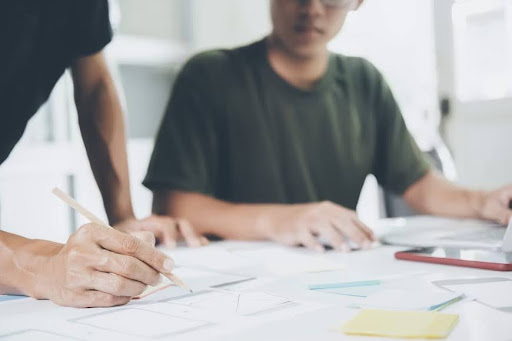 Two professionals working on a PCB schematic design 