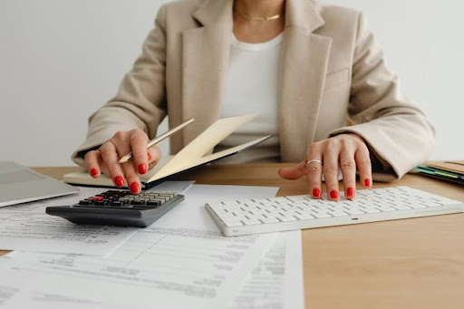 A woman calculates the financial returns of a project using a calculator.