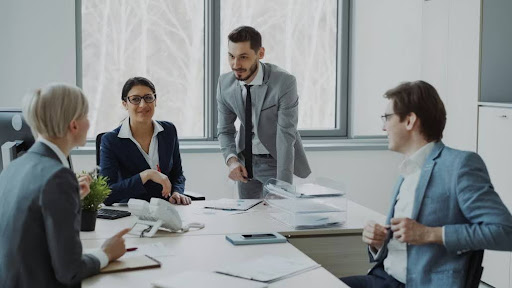 Business professionals collaborating around a conference table to evaluate patent filing strategy. Business professionals collaborating around a conference table to evaluate patent filing strategy.