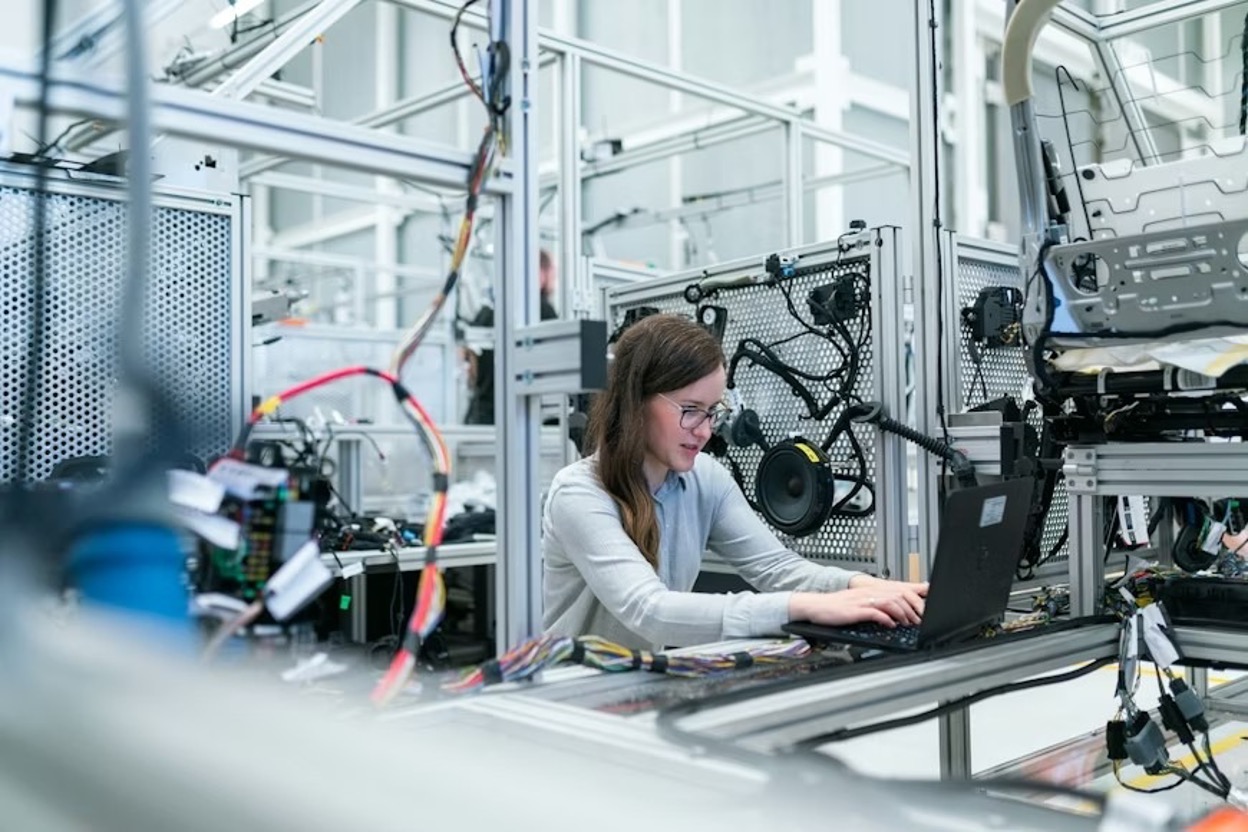 A woman in a manufacturing industry using a black laptop computer
