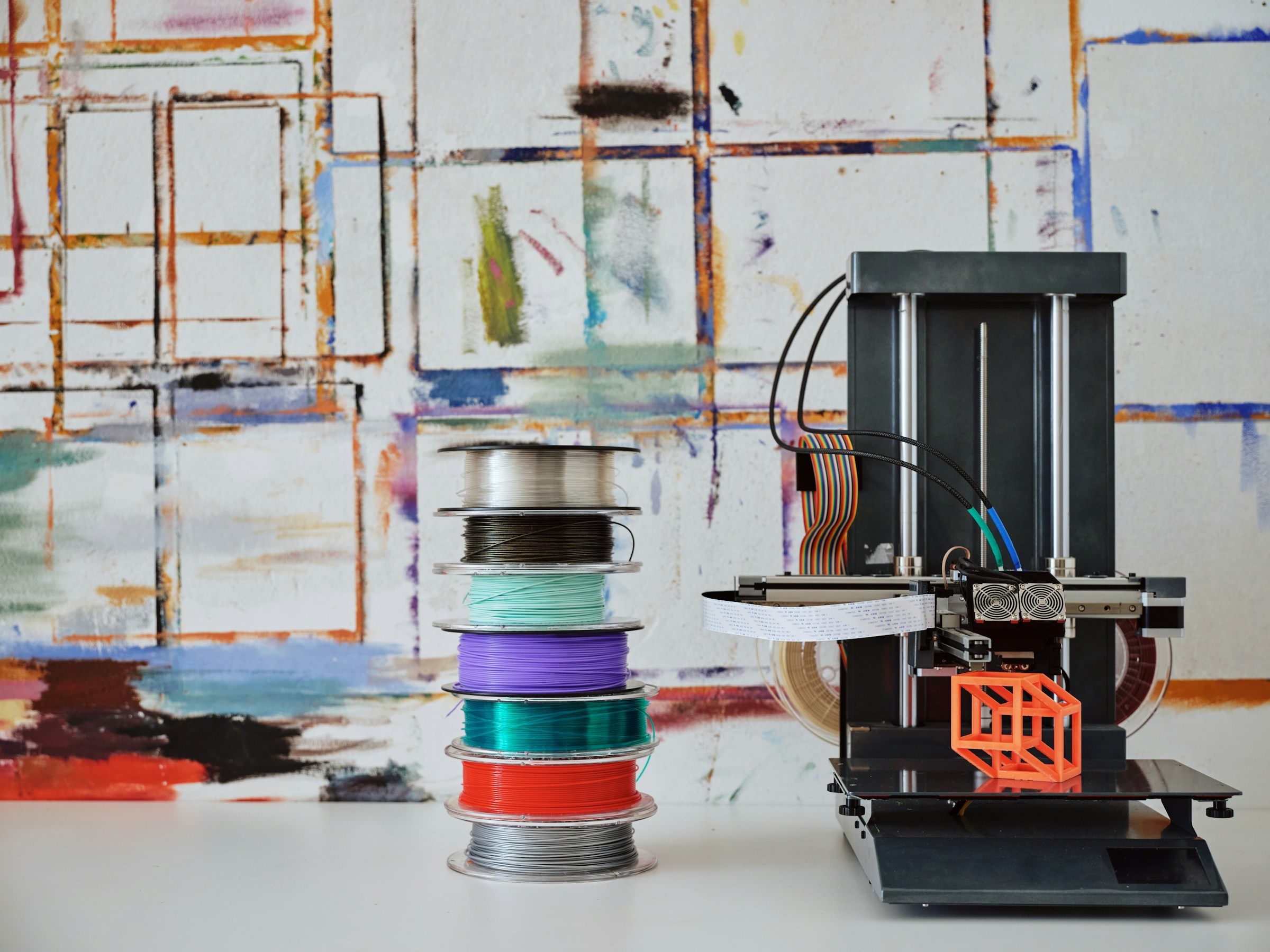 stack of wires sitting next to a 3d printer