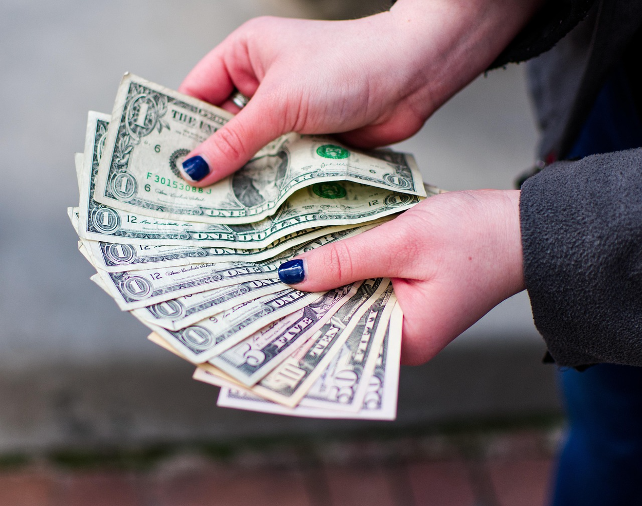 A hand holding a wad of cash.
