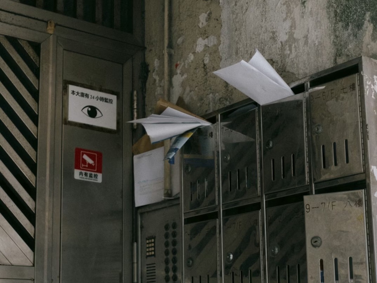 A bunch of mailboxes sitting next to each other with abandoned mail sticking out