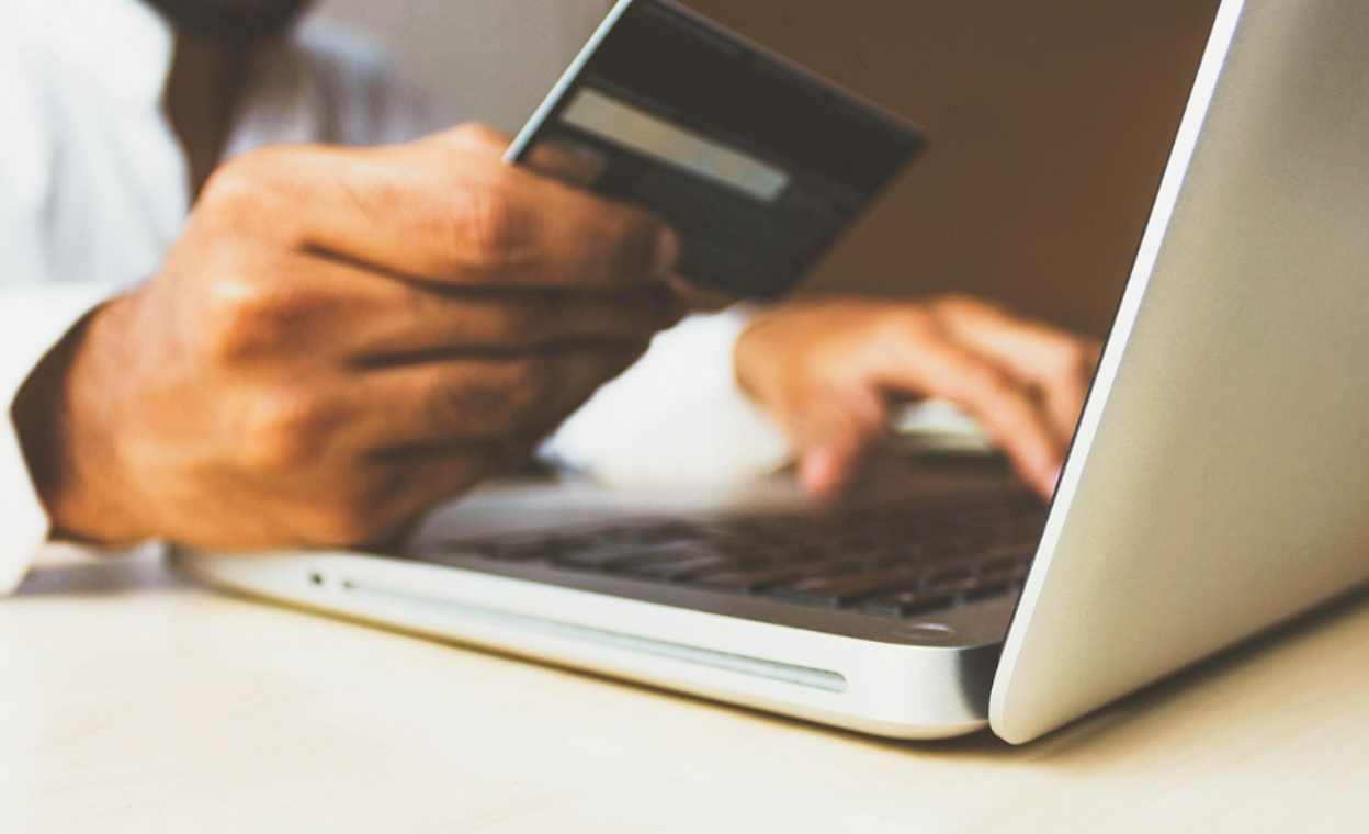 An inventor paying USPTO maintenance fees online using a credit card and a laptop