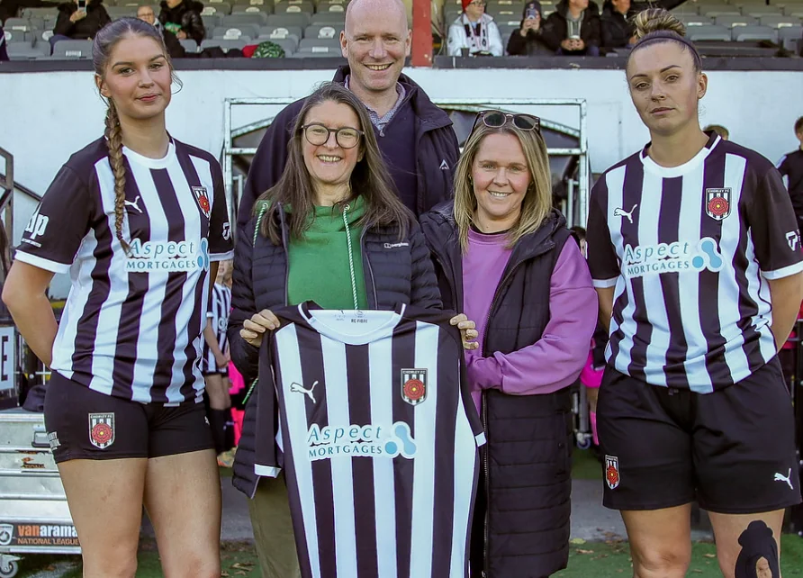 Two Chorley FC Women players and three adults holding a Chorley FC Women shirt with the Aspect Mortgages logo