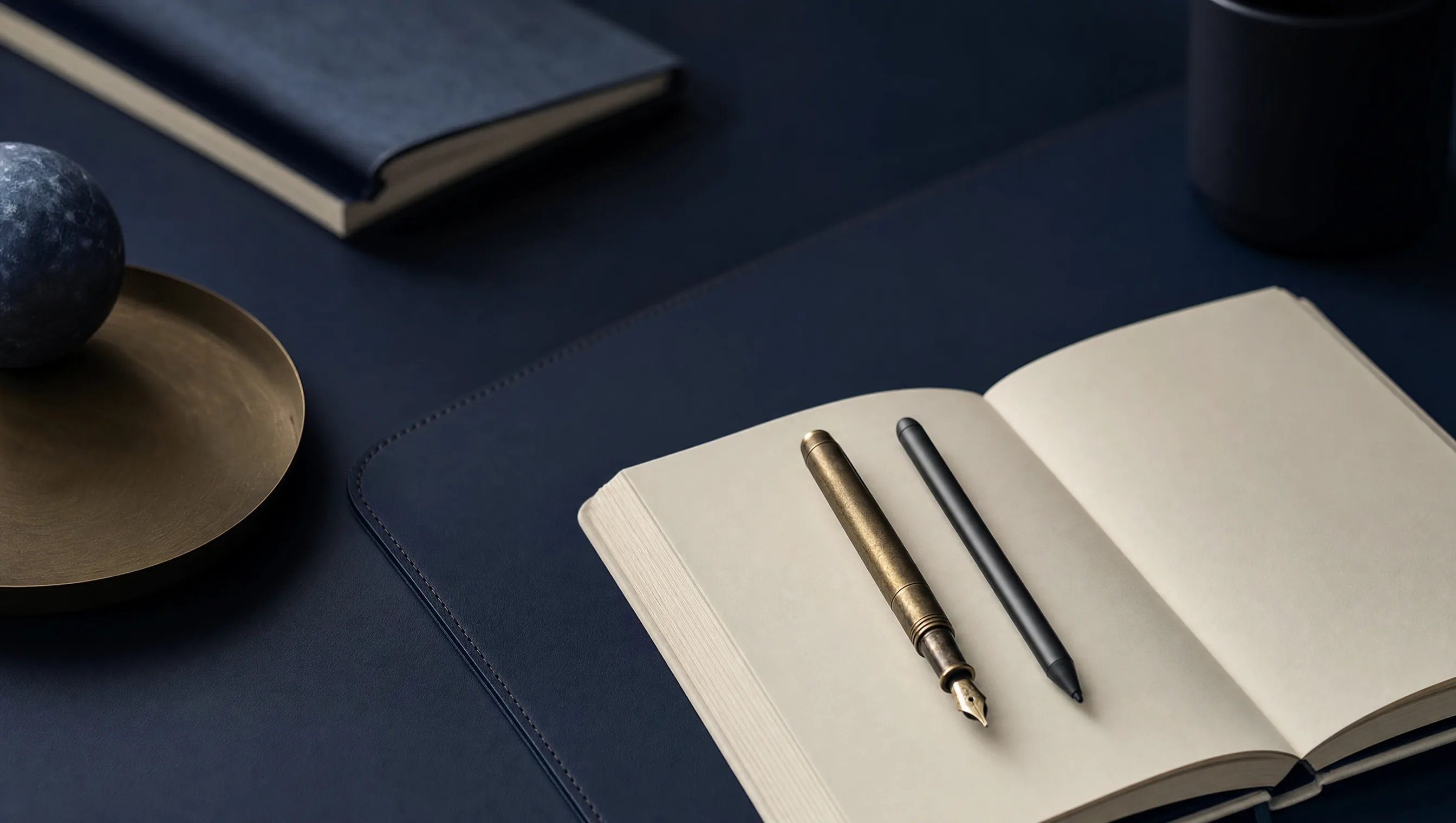 Pluma fuente antigua de latón y stylus moderno recargados en paralelo sobre la misma libreta abierta