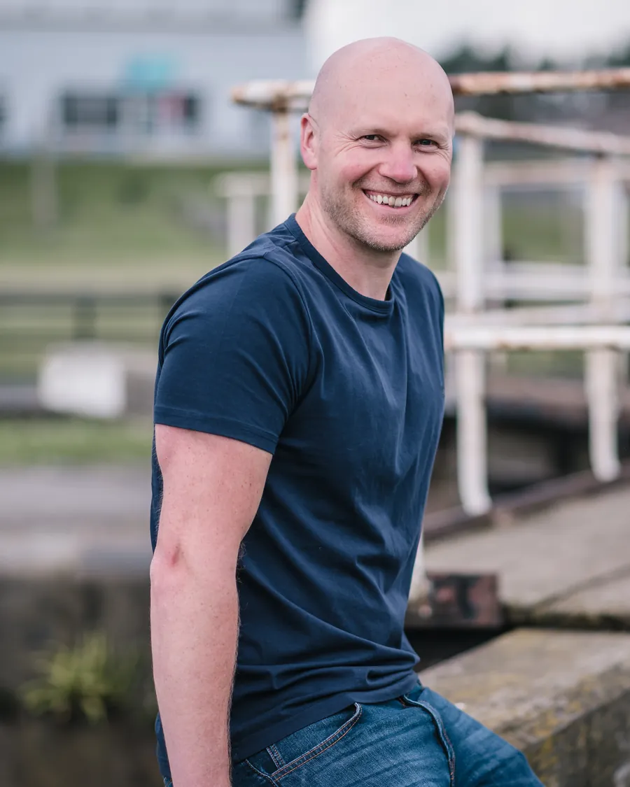 Graham Hurst sitting by a canal lock, smiling