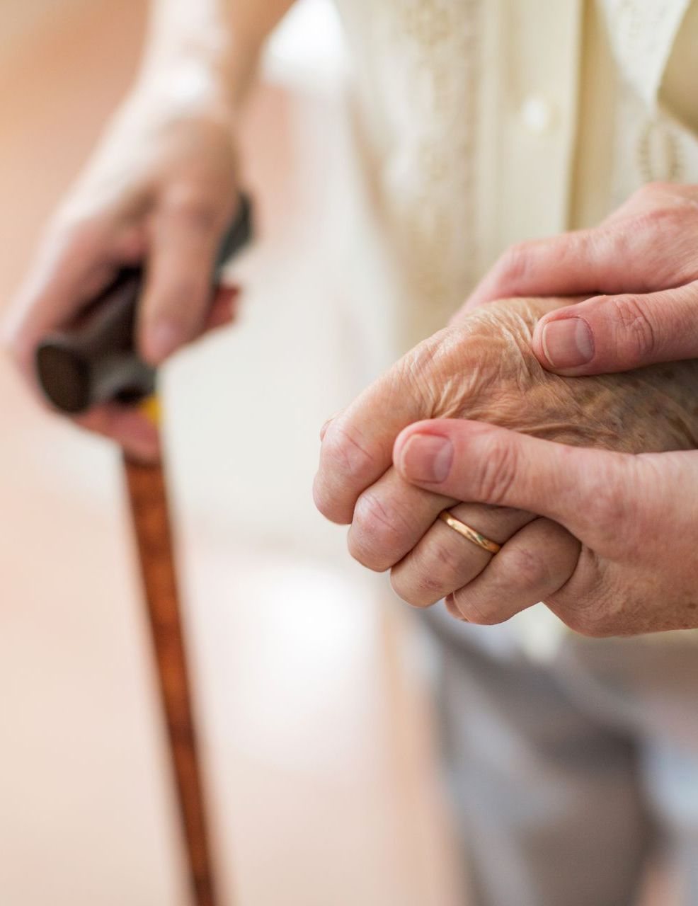 Therapist supporting an older adult walking with a cane