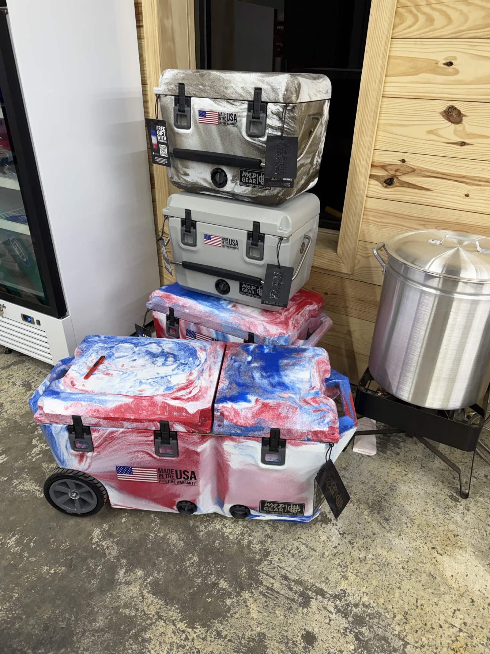 Stocking phase — American flag MP2 Gear coolers staged near a giant aluminum stockpot