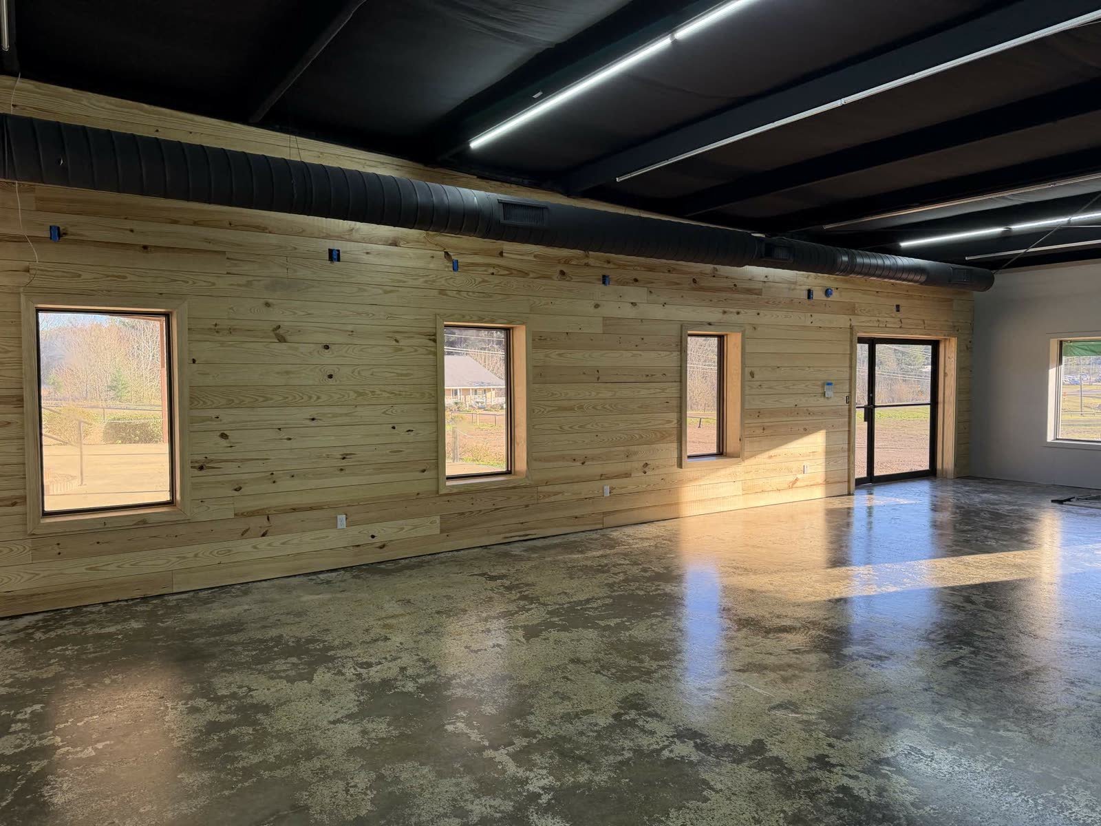 Cardinal Hardware after the rebuild — pine plank wall, polished concrete, big windows