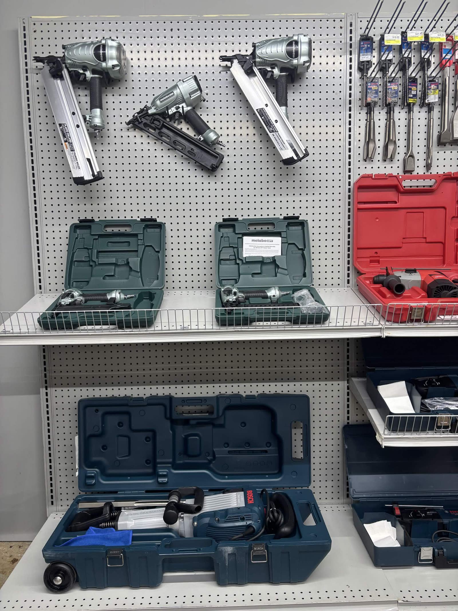 Pneumatic Metabo nail guns and Bosch demolition tools on the rental wall