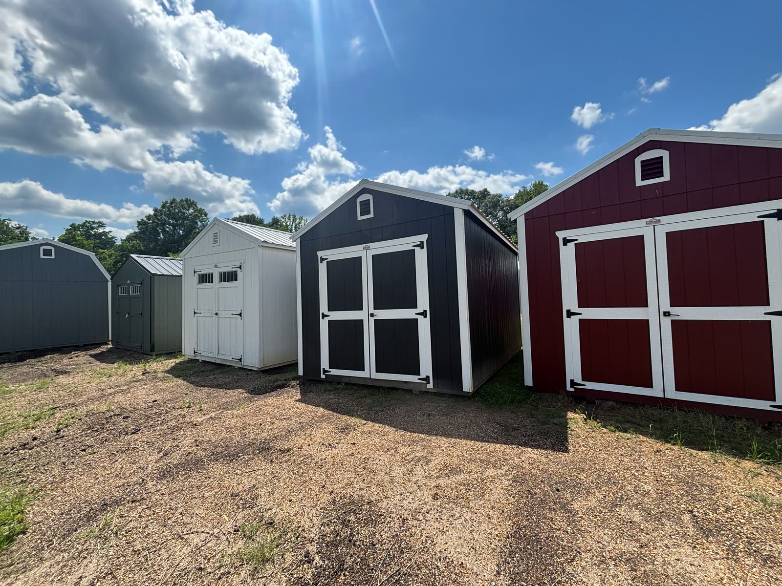 Wide view of multiple Stor-Mor lofted barns and utility sheds on the Cardinal Hardware lot in Summit, MS