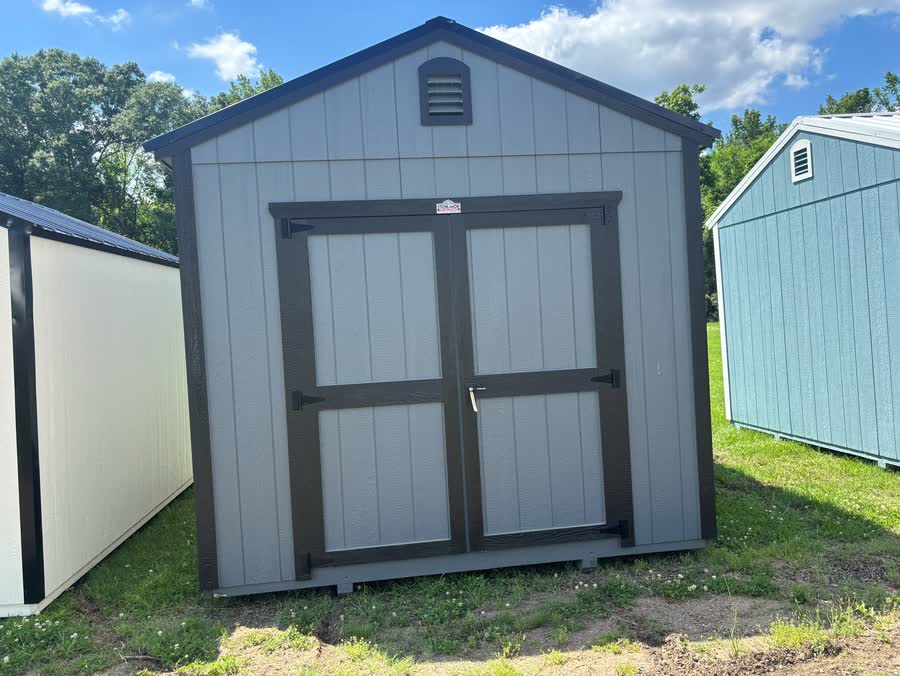 Two-tone gray Stor-Mor utility shed with charcoal trim, cross-buck doors and gable vent at Cardinal Hardware
