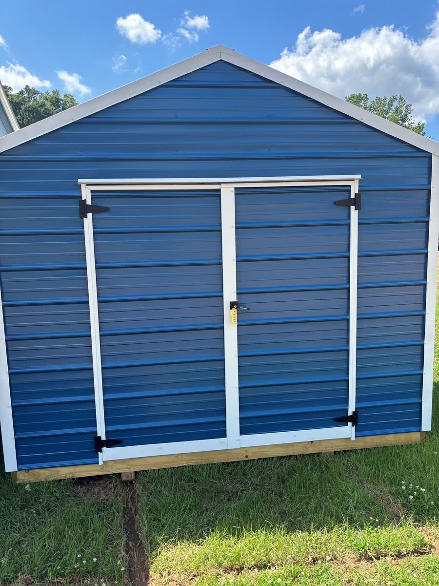 Bright blue Stor-Mor metal utility shed with white-trim double doors at Cardinal Hardware