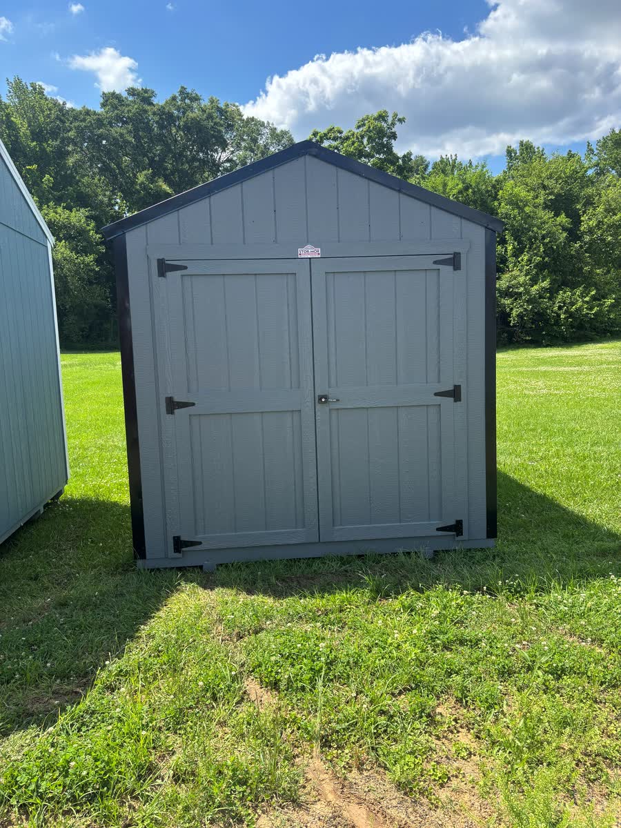 Compact light-gray Stor-Mor utility shed with charcoal trim and double doors at Cardinal Hardware