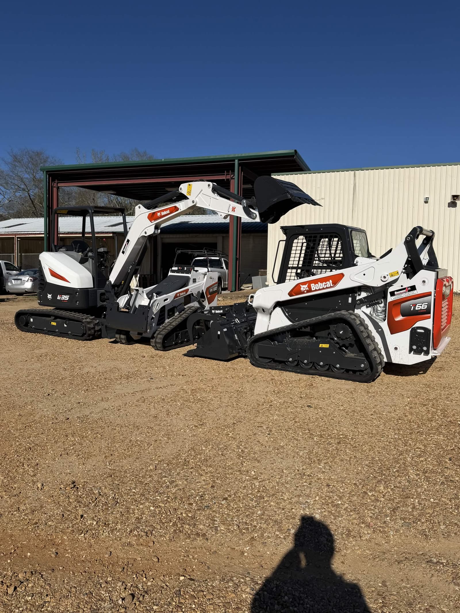Bobcat E35 mini excavator parked alongside a Bobcat T66 skid steer behind the storefront at Cardinal Hardware