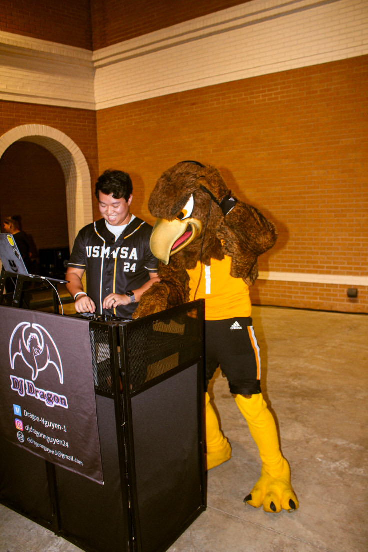 DJ Dragon at his branded booth performing alongside the Southern Miss Seymour the Eagle mascot