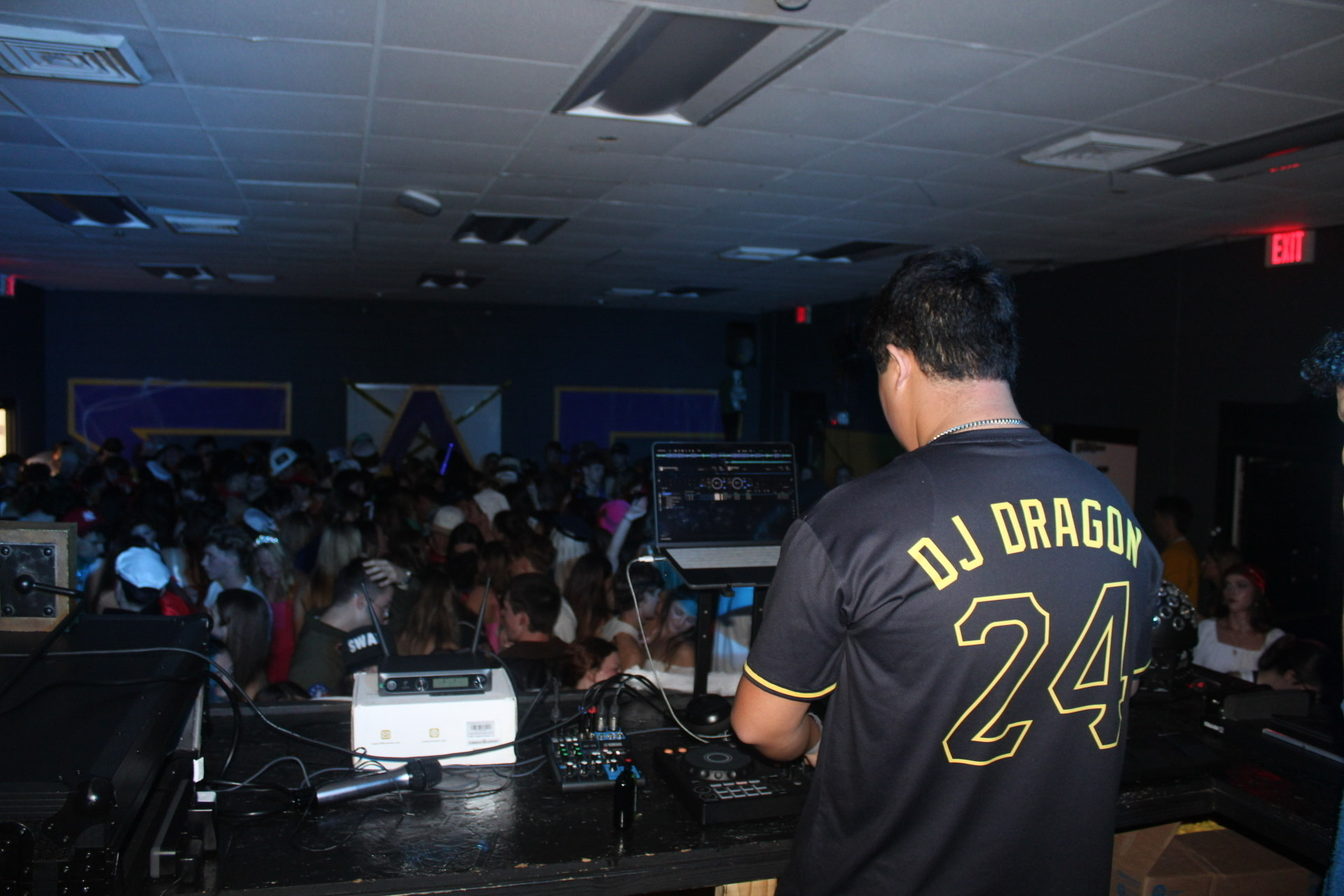 DJ Dragon performing live with the DJ Dragon 24 jersey, lighting and crowd at a party event