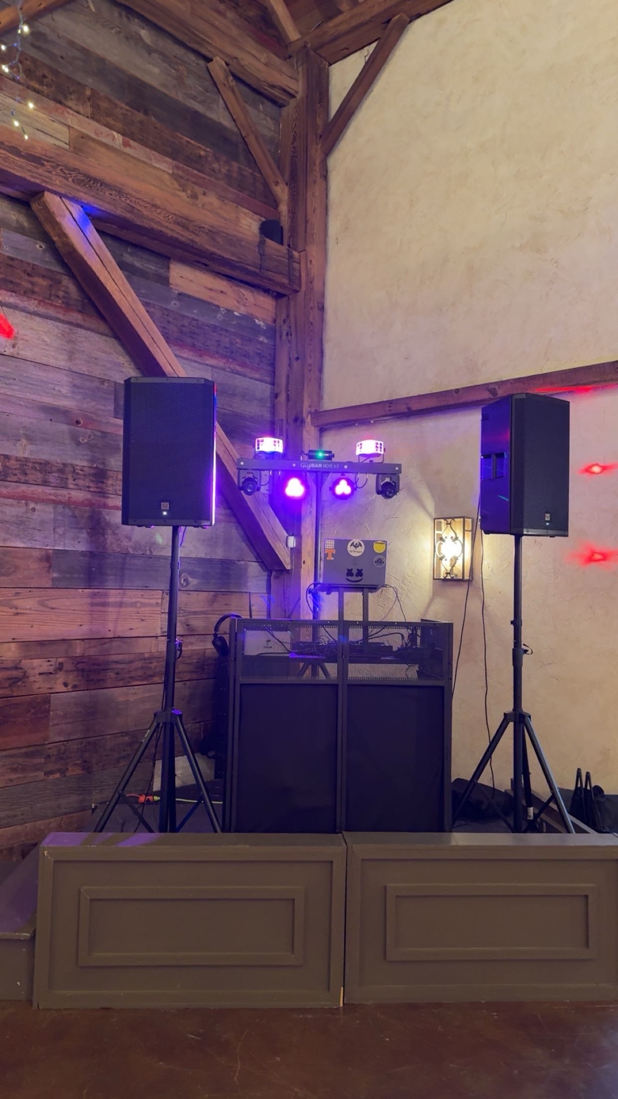 DJ Dragon professional wedding setup with speakers and dancefloor lighting in a rustic barn venue